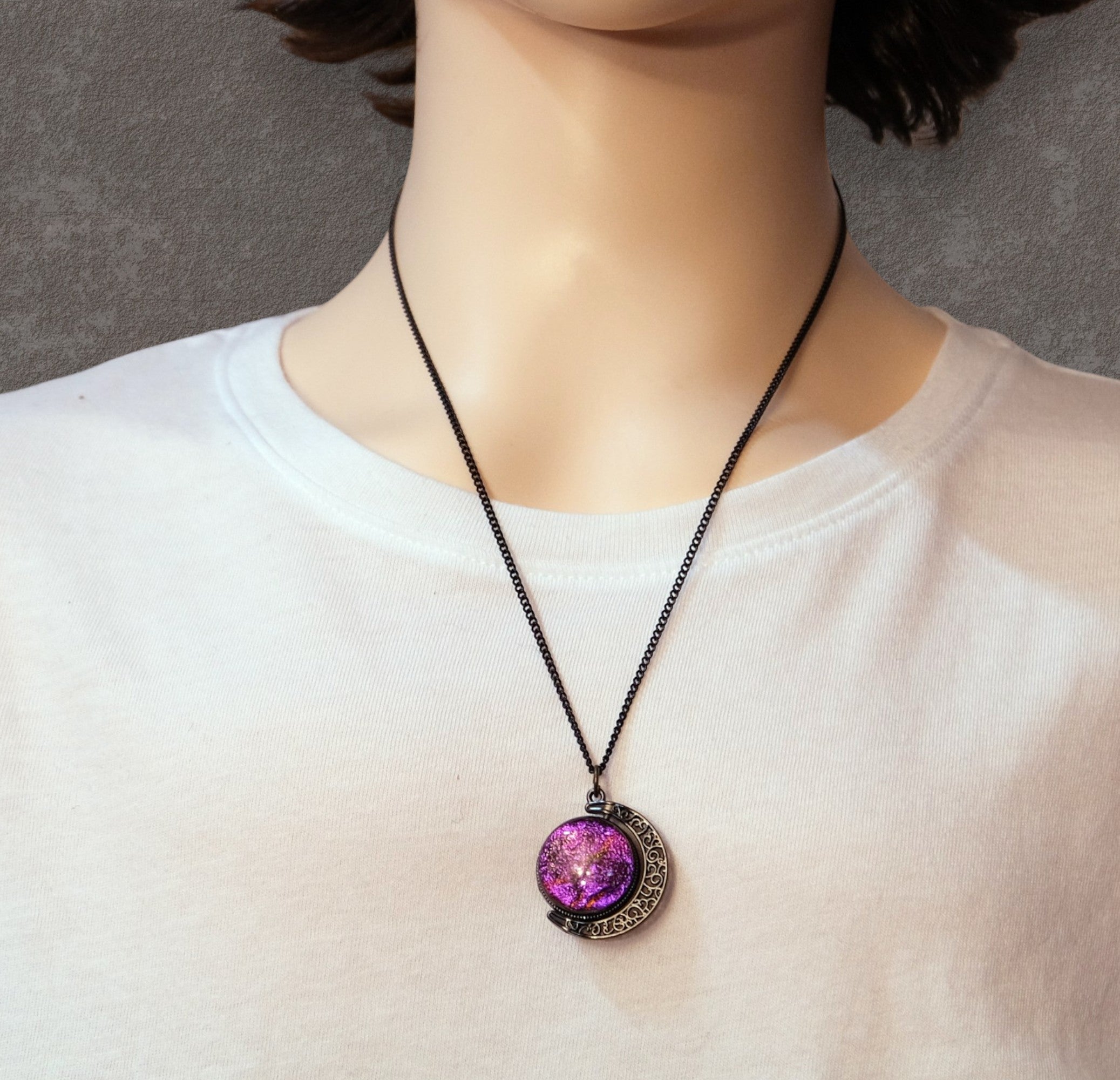 Necklace with a purple pendant on a mannequin wearing a white shirt.