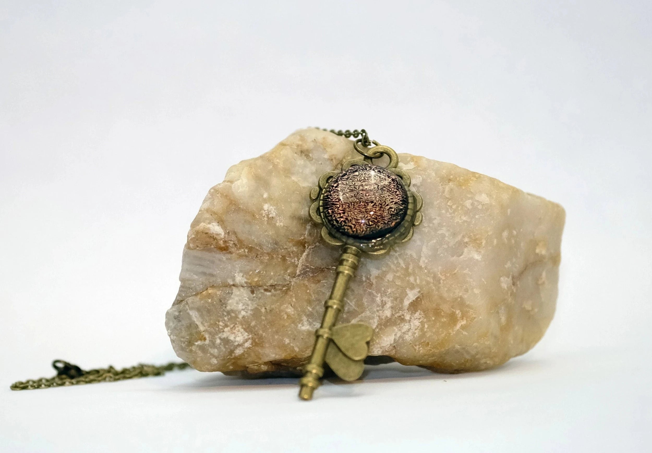 Antiqued Brass Flowered Skeleton Key with Fused Glass Orange Dichroic cabochon on 24 inch brass plated chain. seeds glassworks. seedsglassworks