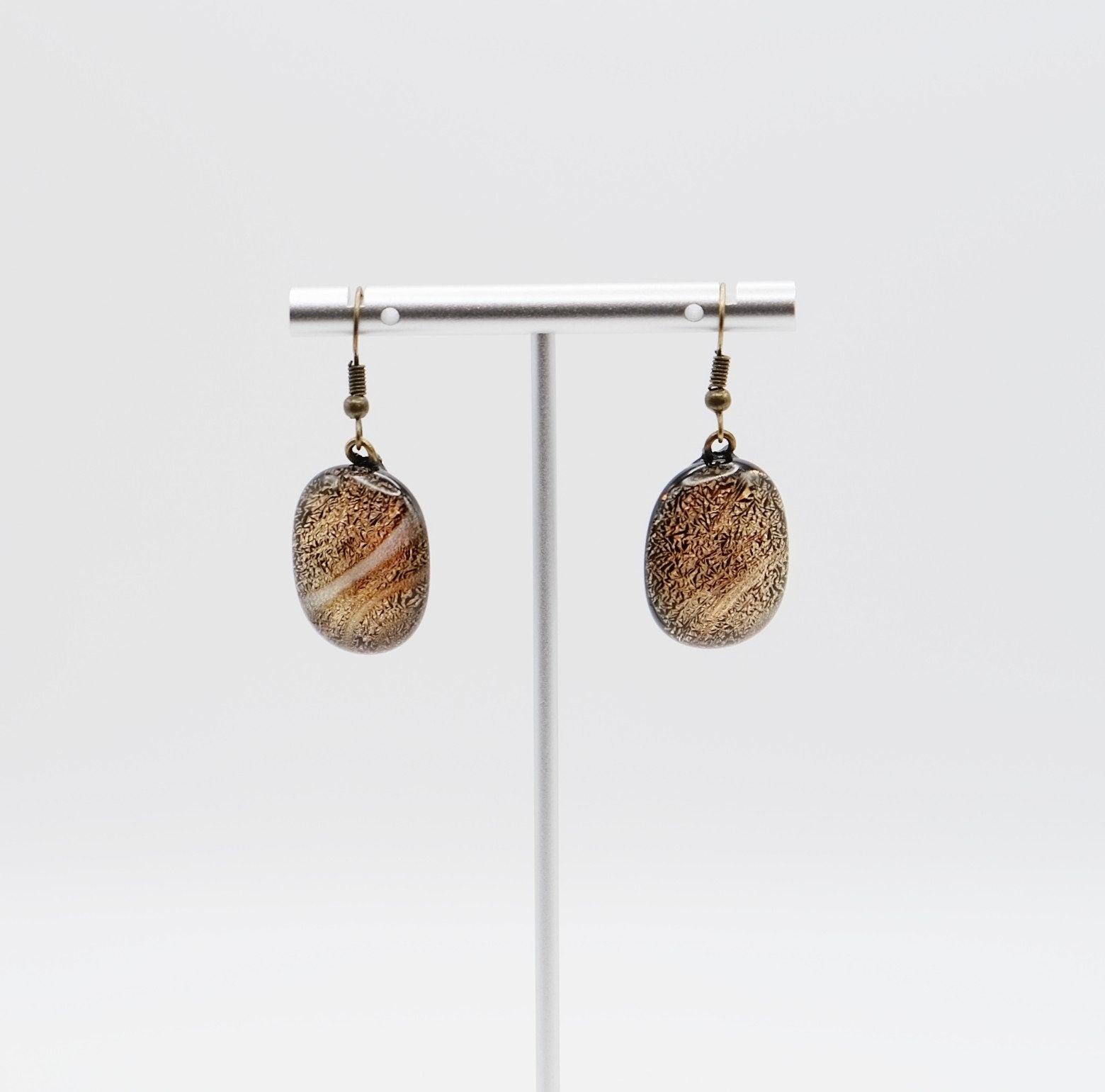 Dichroic orange and black fused glass pierced dangling earrings on antiqued brass tone french wires. Approx 1.5 inches total length seeds glassworks seedsglassworks