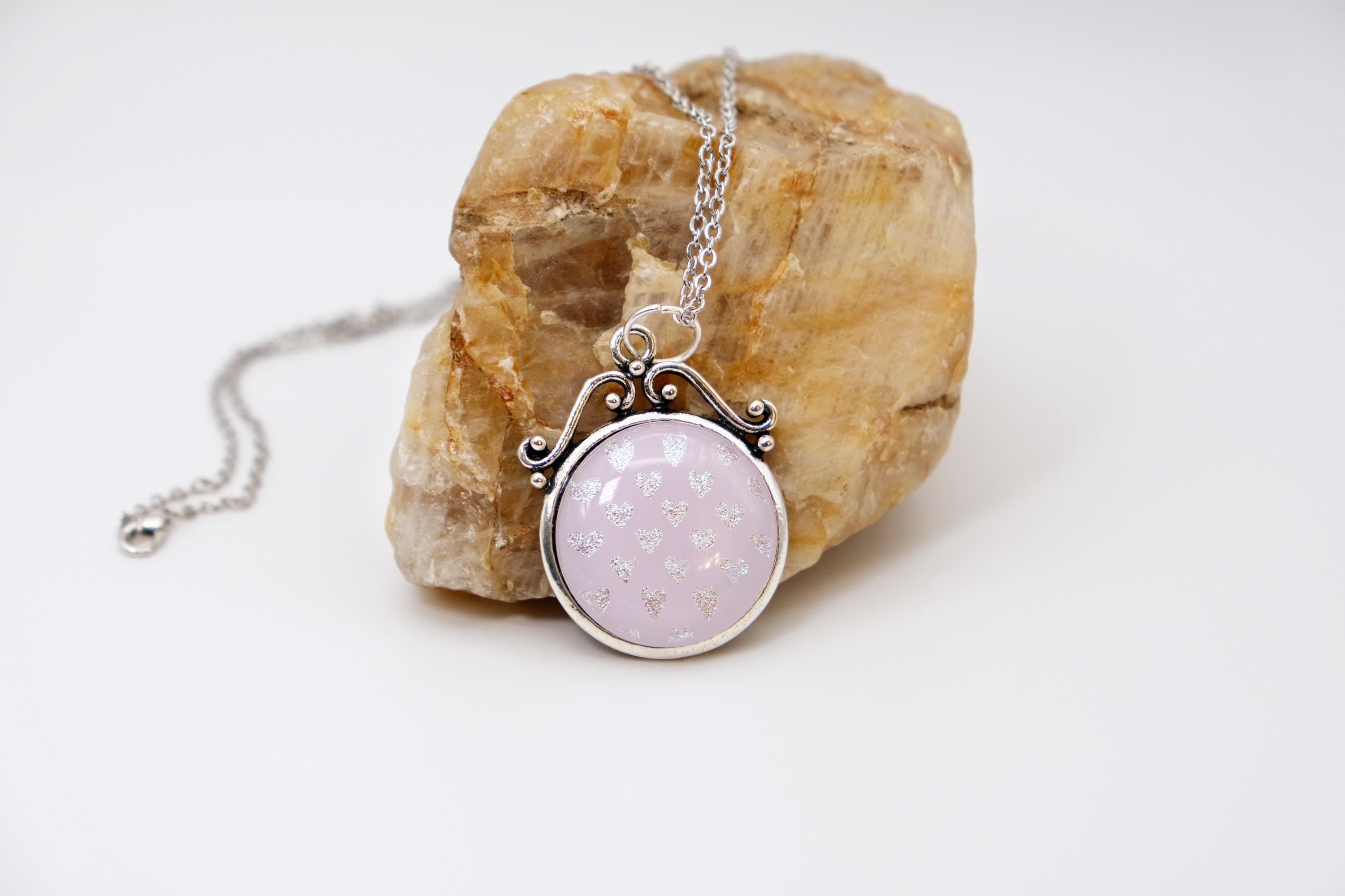 Silver tone scroll work design pendant necklace with Pink Fused Glass and dichroic hearts pattern cabochon on 24 inch steel chain jewelry. seeds glassworks seedsglassworks