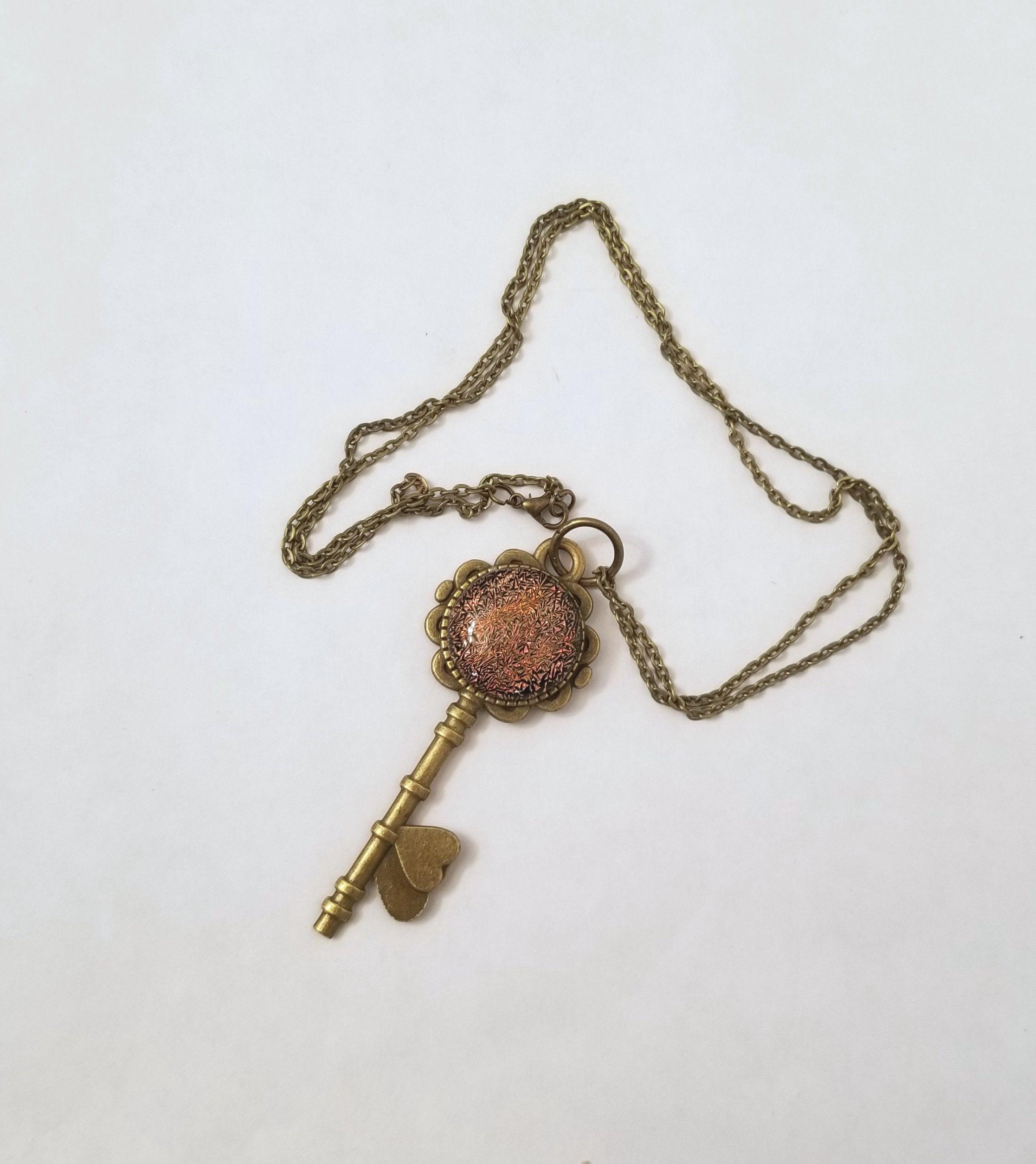 Antiqued Brass Flowered Skeleton Key with Fused Glass Orange Dichroic cabochon on 24 inch brass plated chain. seeds glassworks. seedsglassworks