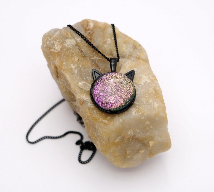 Products Black Cat pendant necklace, with color shifting pink/purple/green dichroic fused glass center stone on a 20 inch black chain seeds glassworks seedsglassworks
