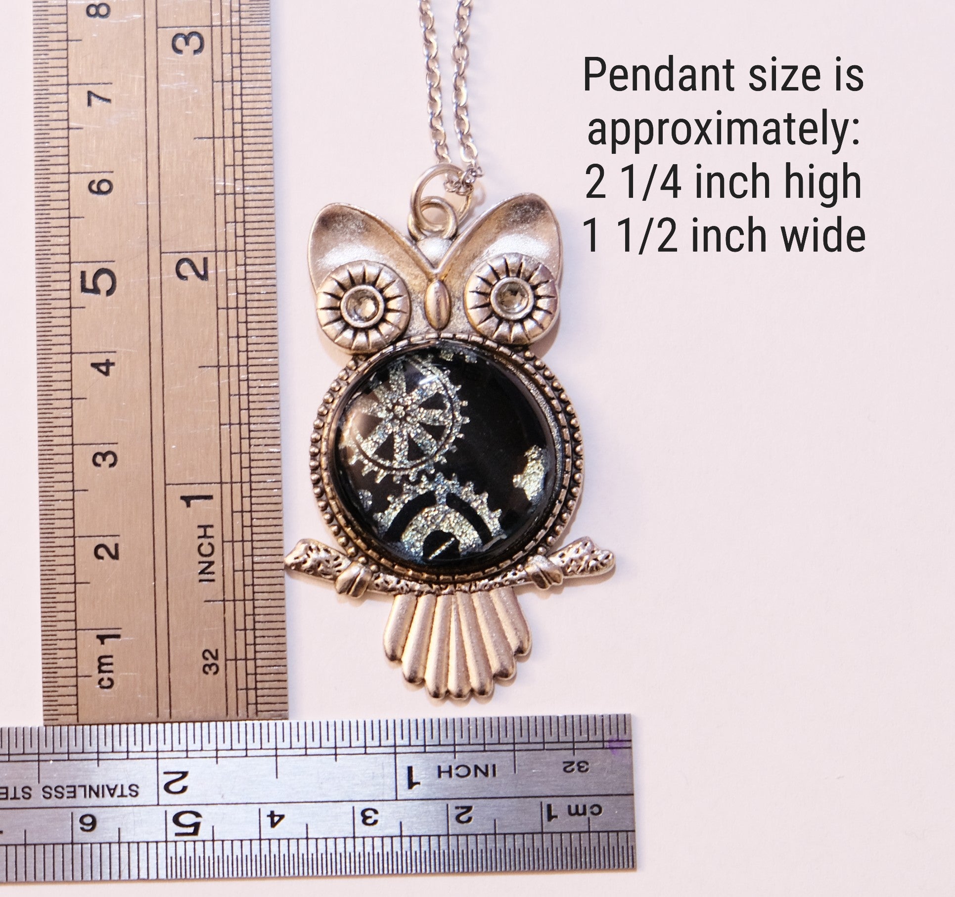 Owl-shaped pendant with measurement details on a white background