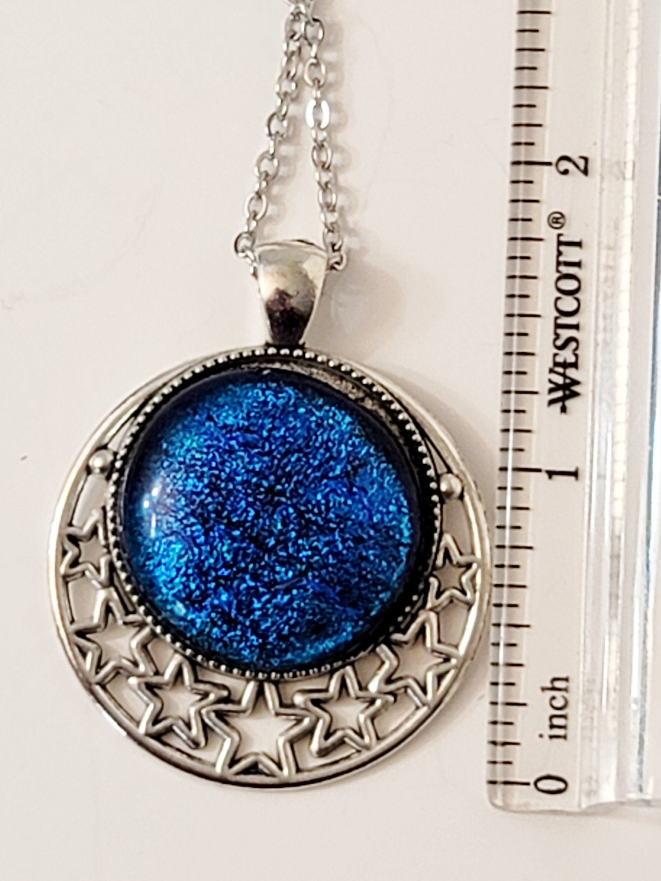 Silver tone Moon and Stars Celestial Pendant Necklace with Royal Blue dichroic glass cabochon on a 20 inch steel metal chain.