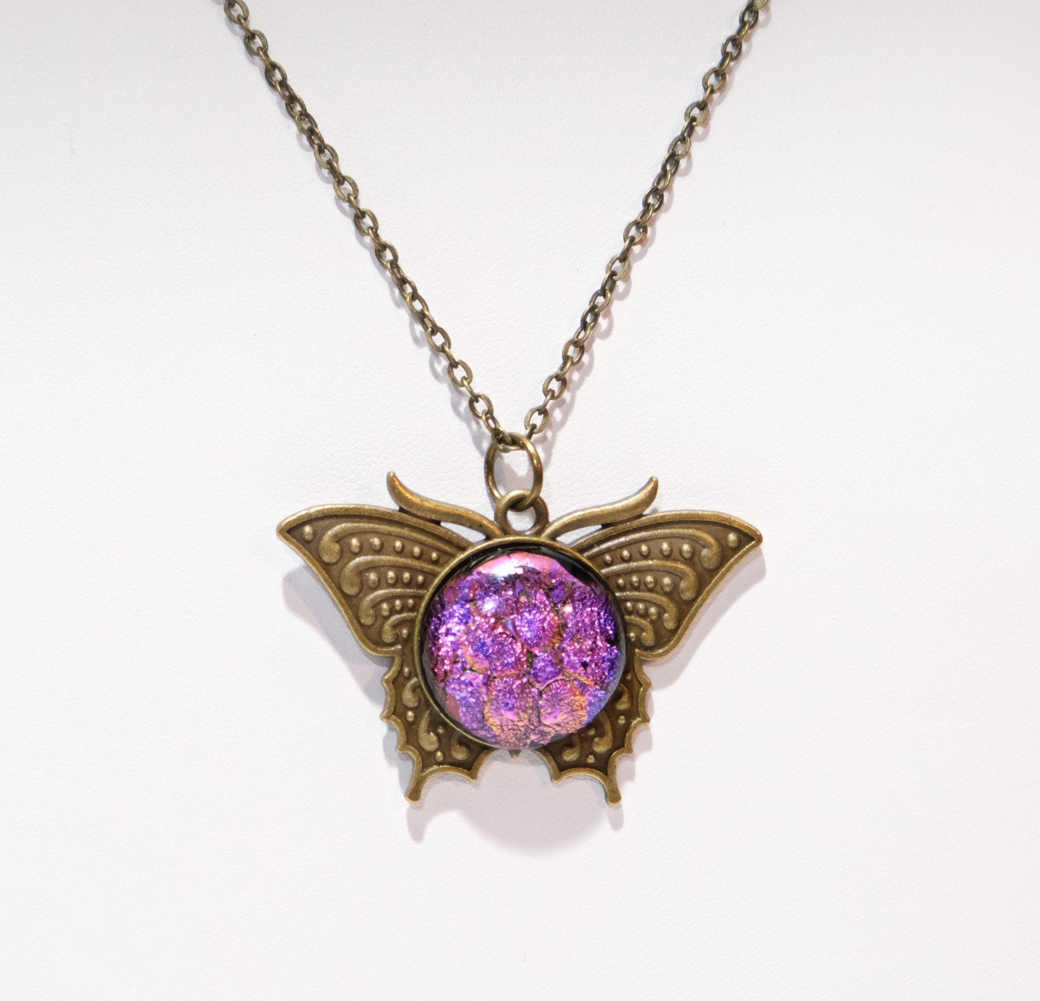 Butterfly pendant necklace, brass tone with pink purple dichroic fused glass center stone on a 20 inch brass tone chain seeds glassworks seedsglassworks