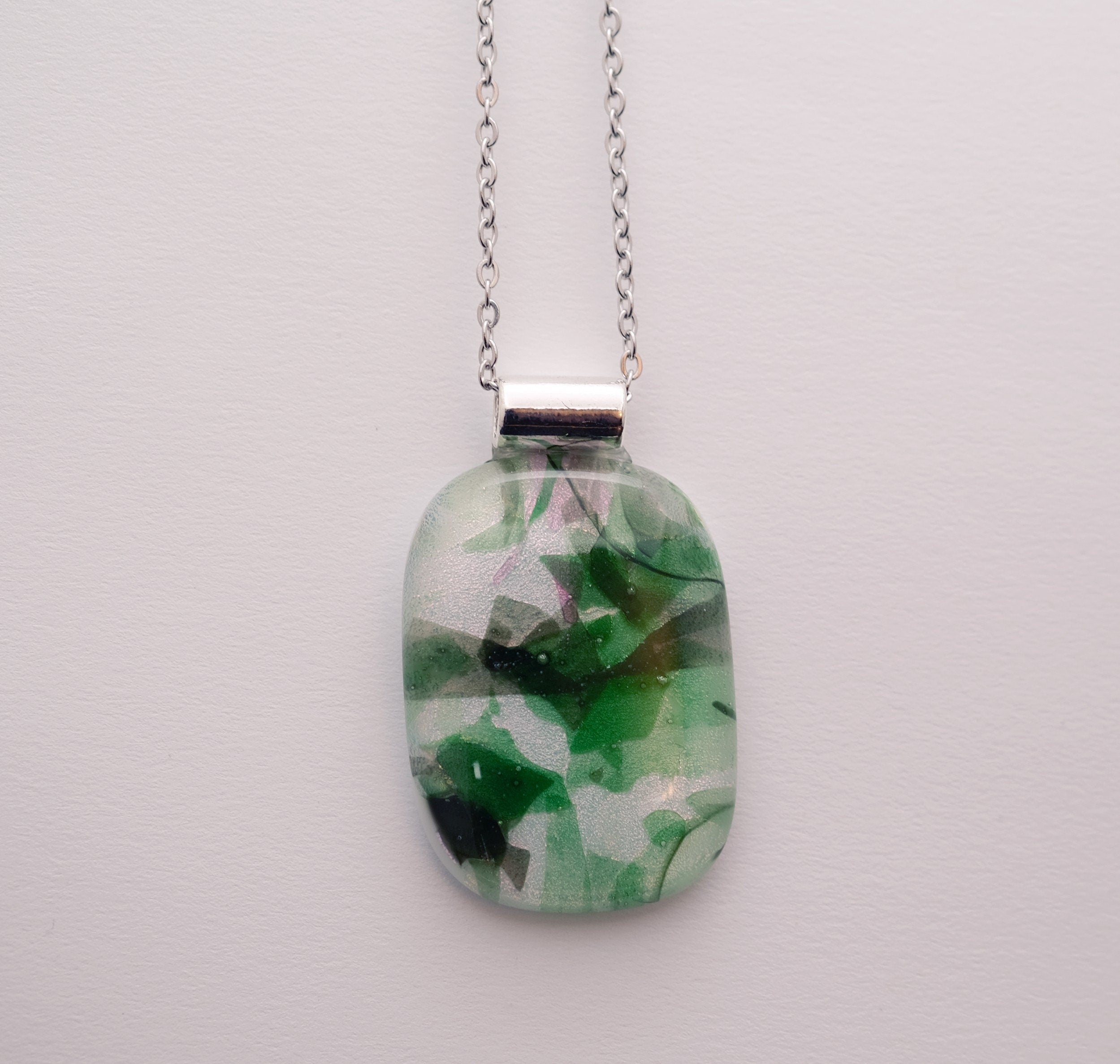 Dichroic green floral on white fused glass statement pendant necklace on 24 inch steel chain. 1.75 x 1 inch pendant seeds glassworks seedsglassworks