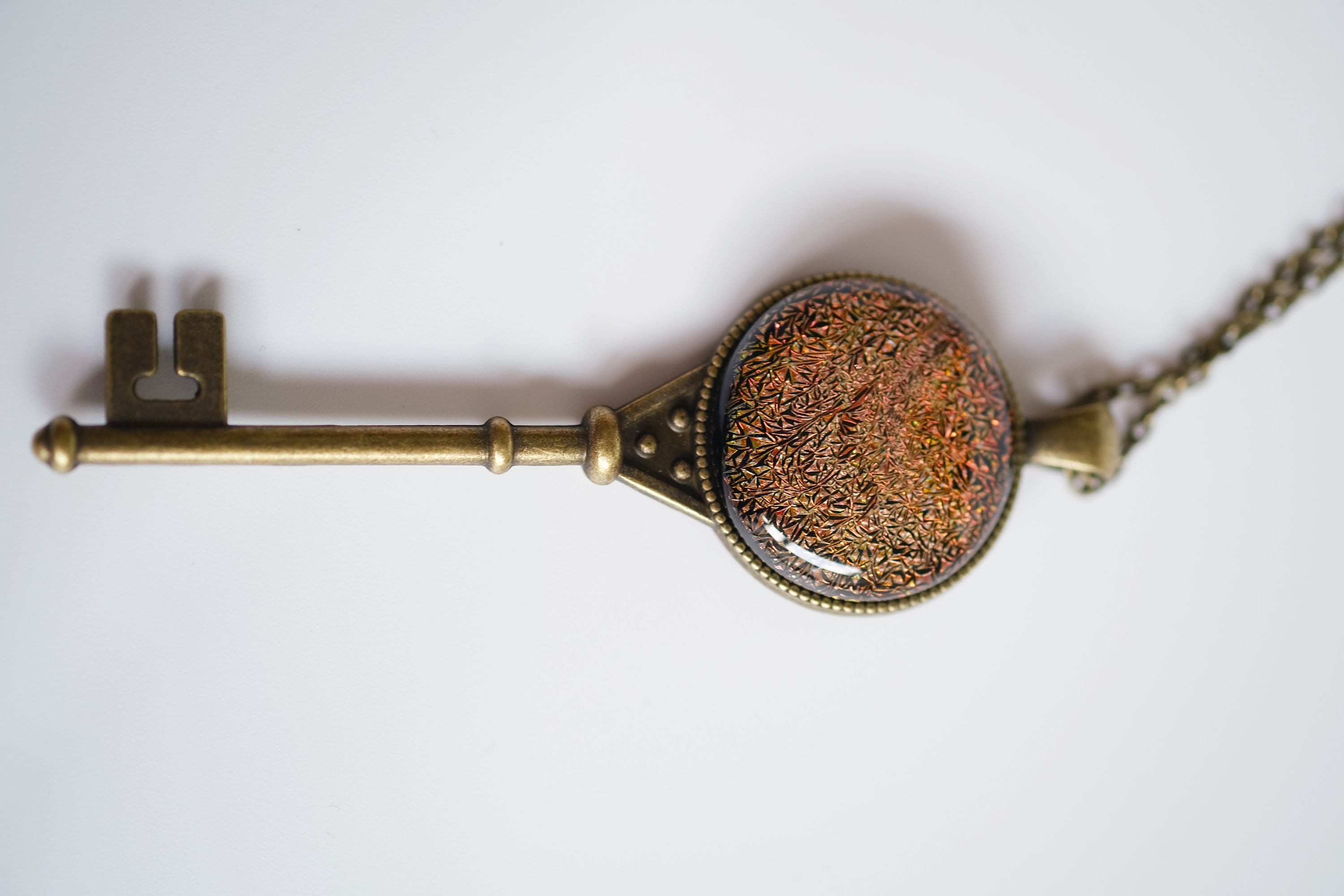 Antiqued Brass  Skeleton Key pendant necklace with Fused Glass Orange Dichroic cabochon on 24 inch brass plated chain jewelry