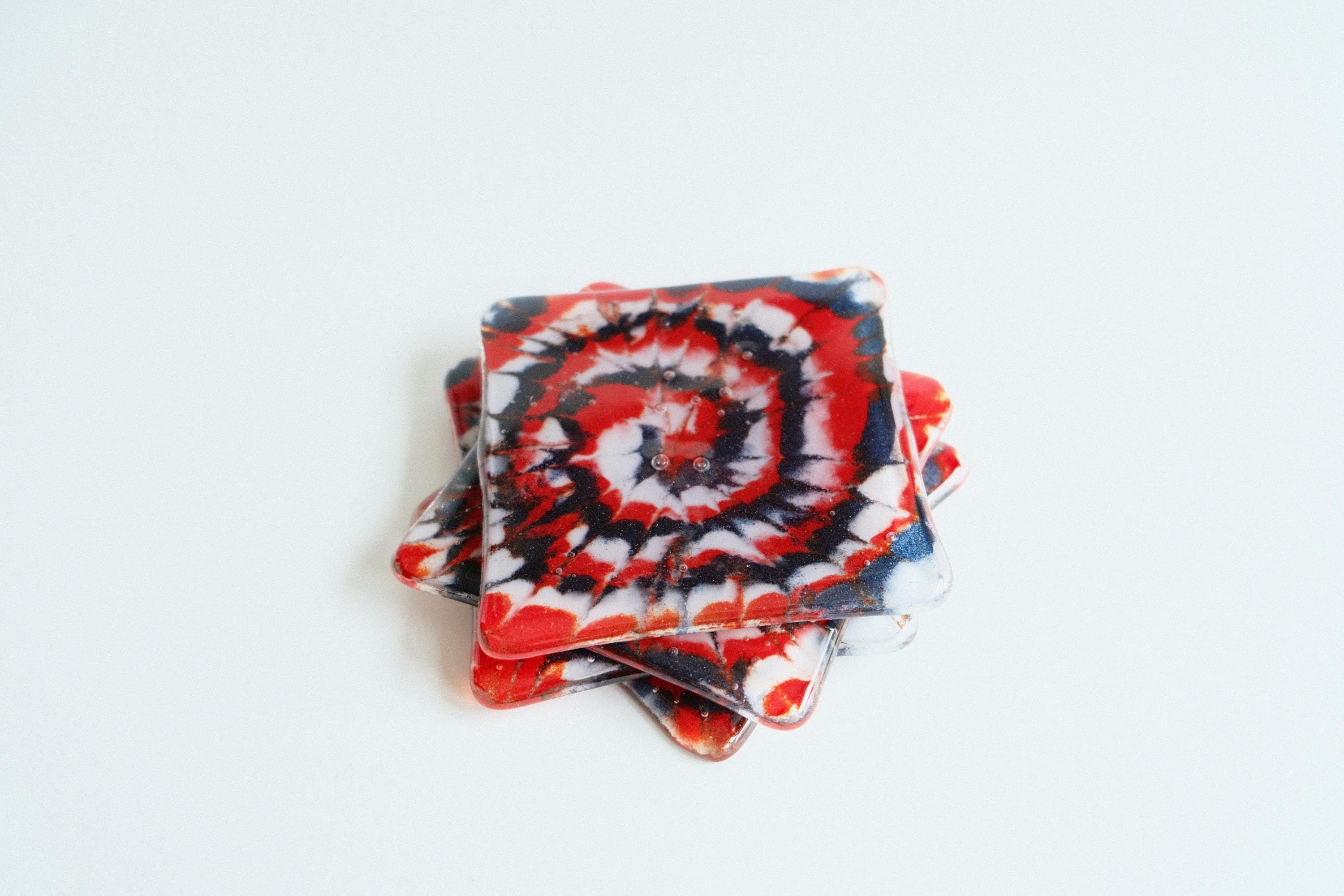 Set of 4 fused glass drink coasters with a red, blue, and white tie-dye design, featuring a patriotic and nautical vibe.