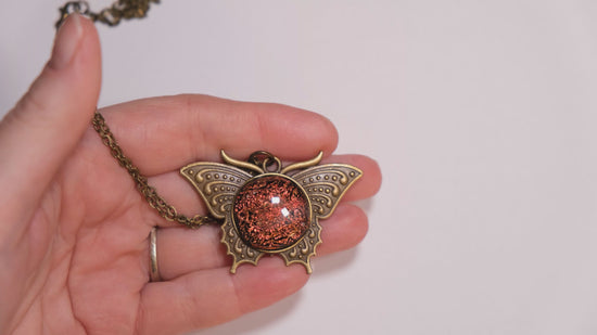 Butterfly pendant necklace, antiqued brass tone with orange dichroic fused glass center stone on a 20 inch antiqued brass chain seeds glassworks seedsglassworks