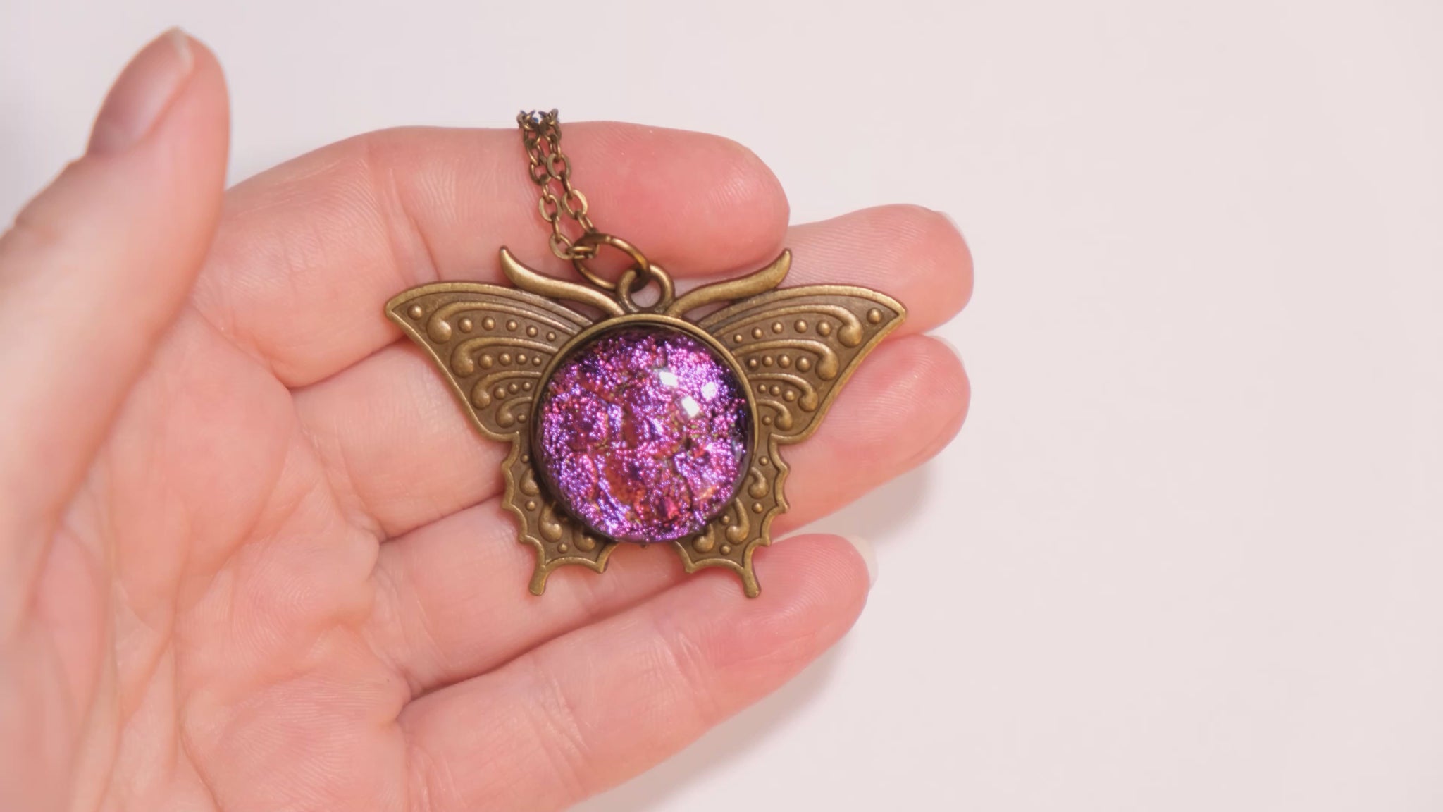 Butterfly pendant necklace, brass tone with pink purple dichroic fused glass center stone on a 20 inch brass tone chain seeds glassworks seedsglassworks