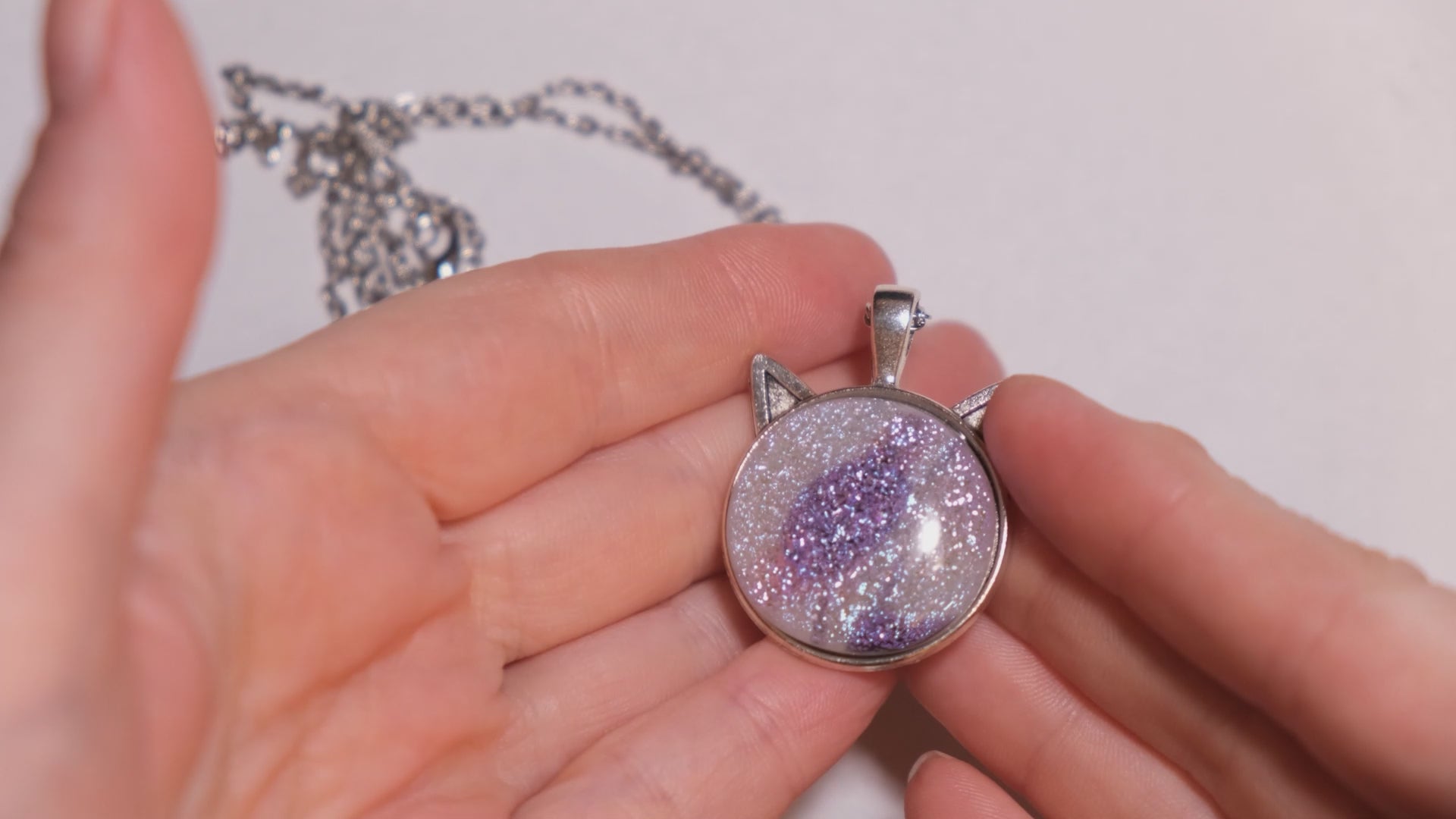 Silver Cat pendant necklace, with pink/purple/white sparkling dichroic fused glass center stone on a 20 inch steel chain seeds glassworks seedsglassworks