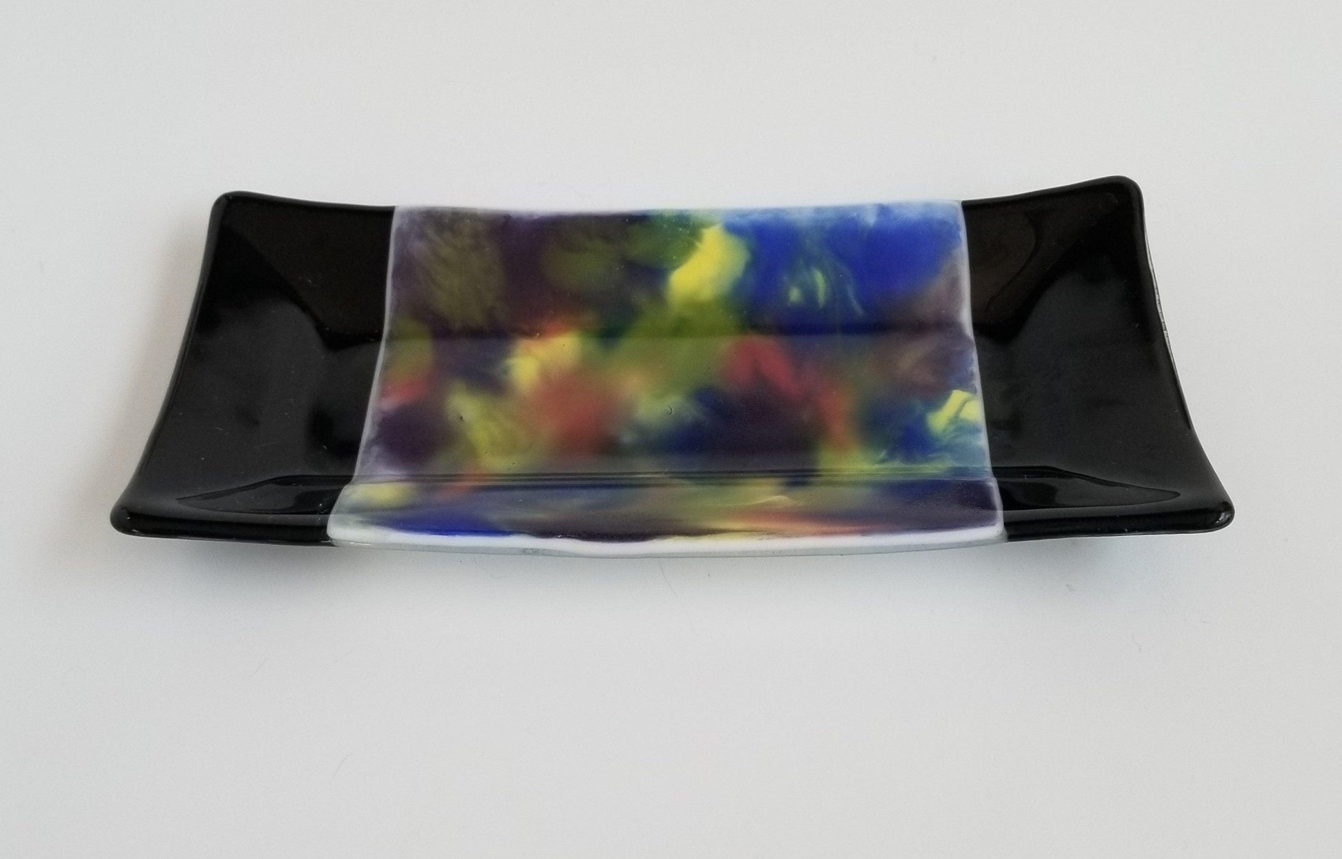 fused glass 10 inch serving plate with colorful rainbow swirls and black accents, from Seeds Glassworks