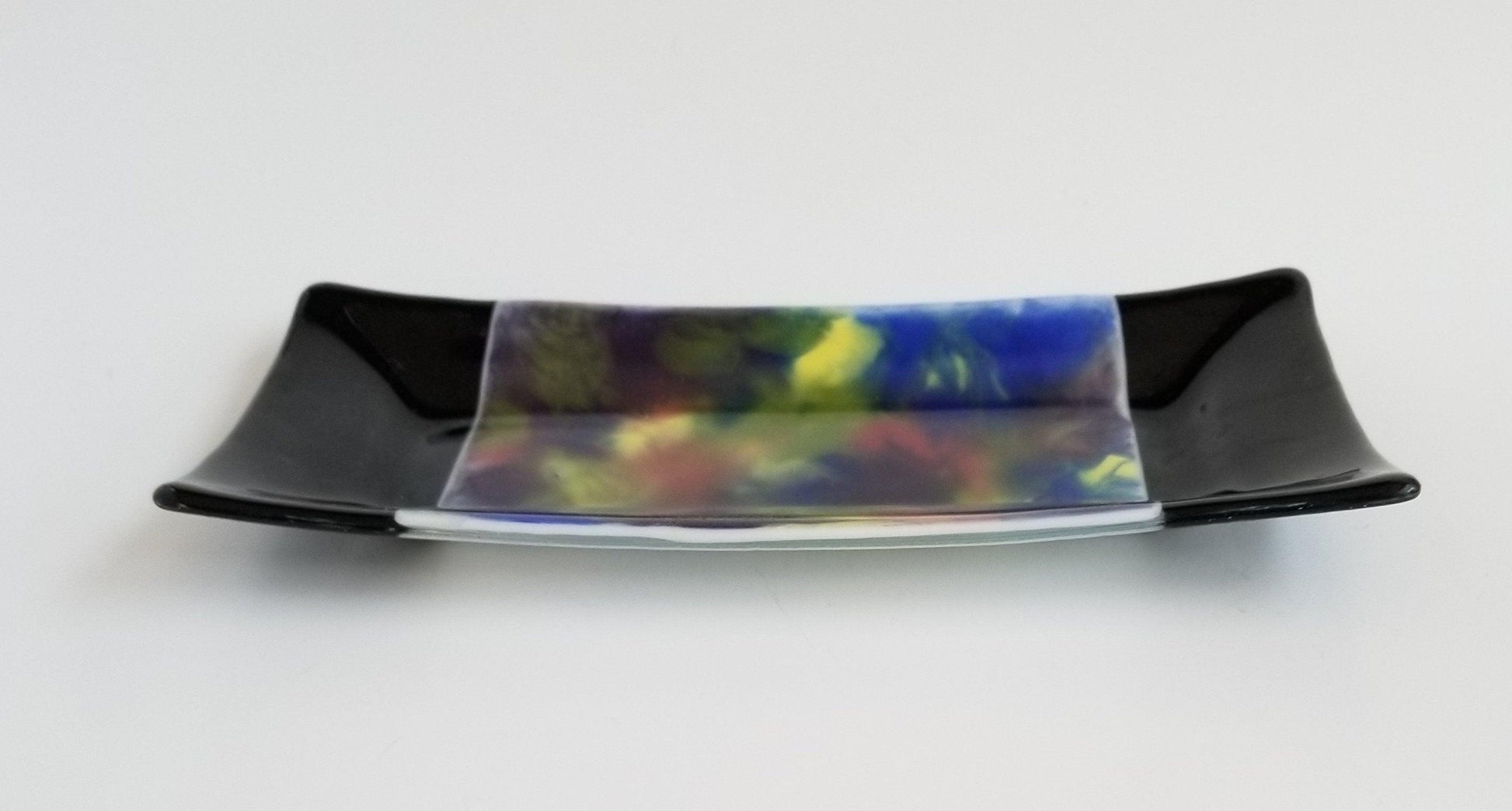 fused glass 10 inch serving plate with colorful rainbow swirls and black accents, from Seeds Glassworks
