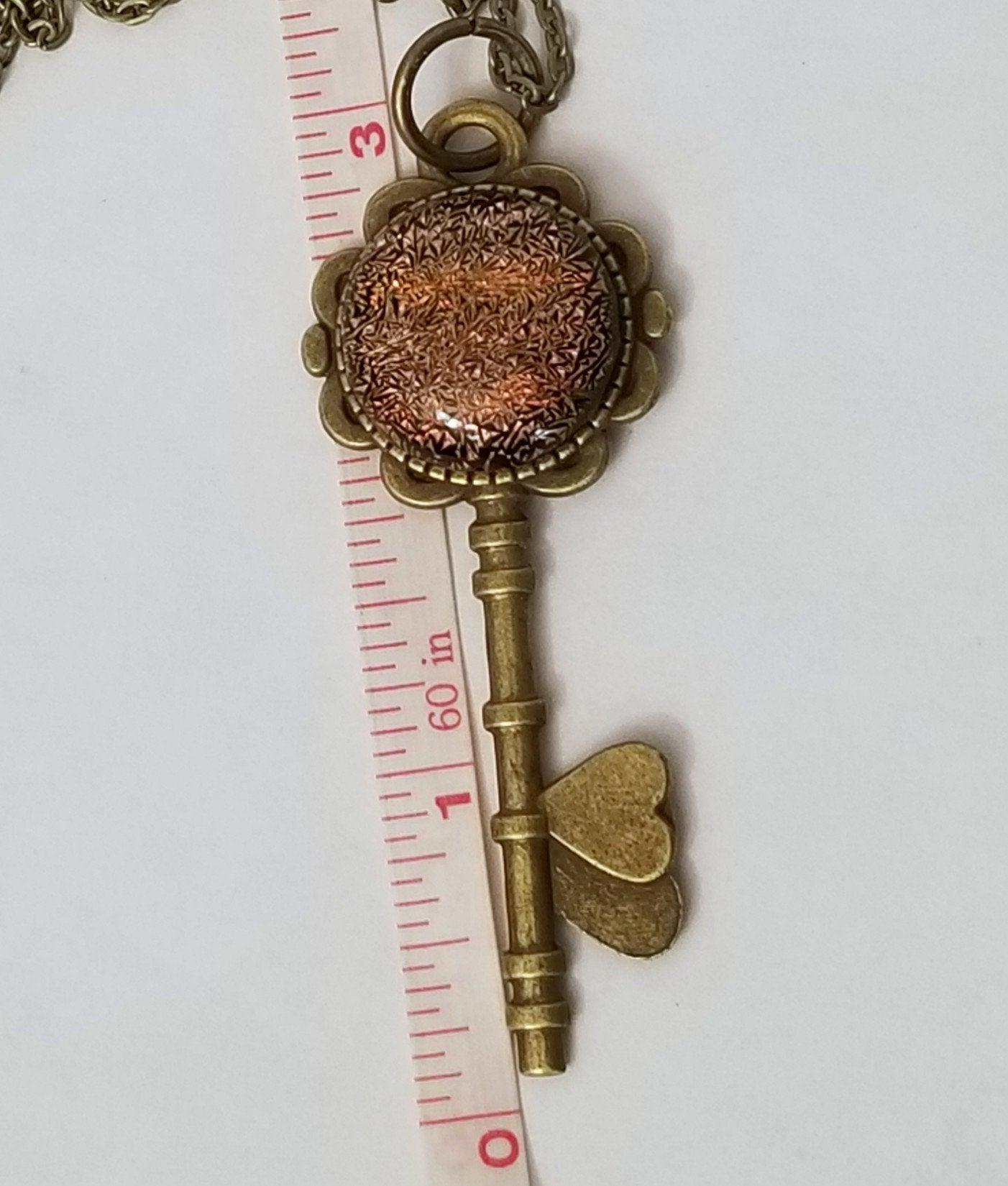 Antiqued Brass  Flowered Skeleton Key with Fused Glass Orange Dichroic cabochon on 24 inch brass plated chain. seeds glassworks seedsglassworks