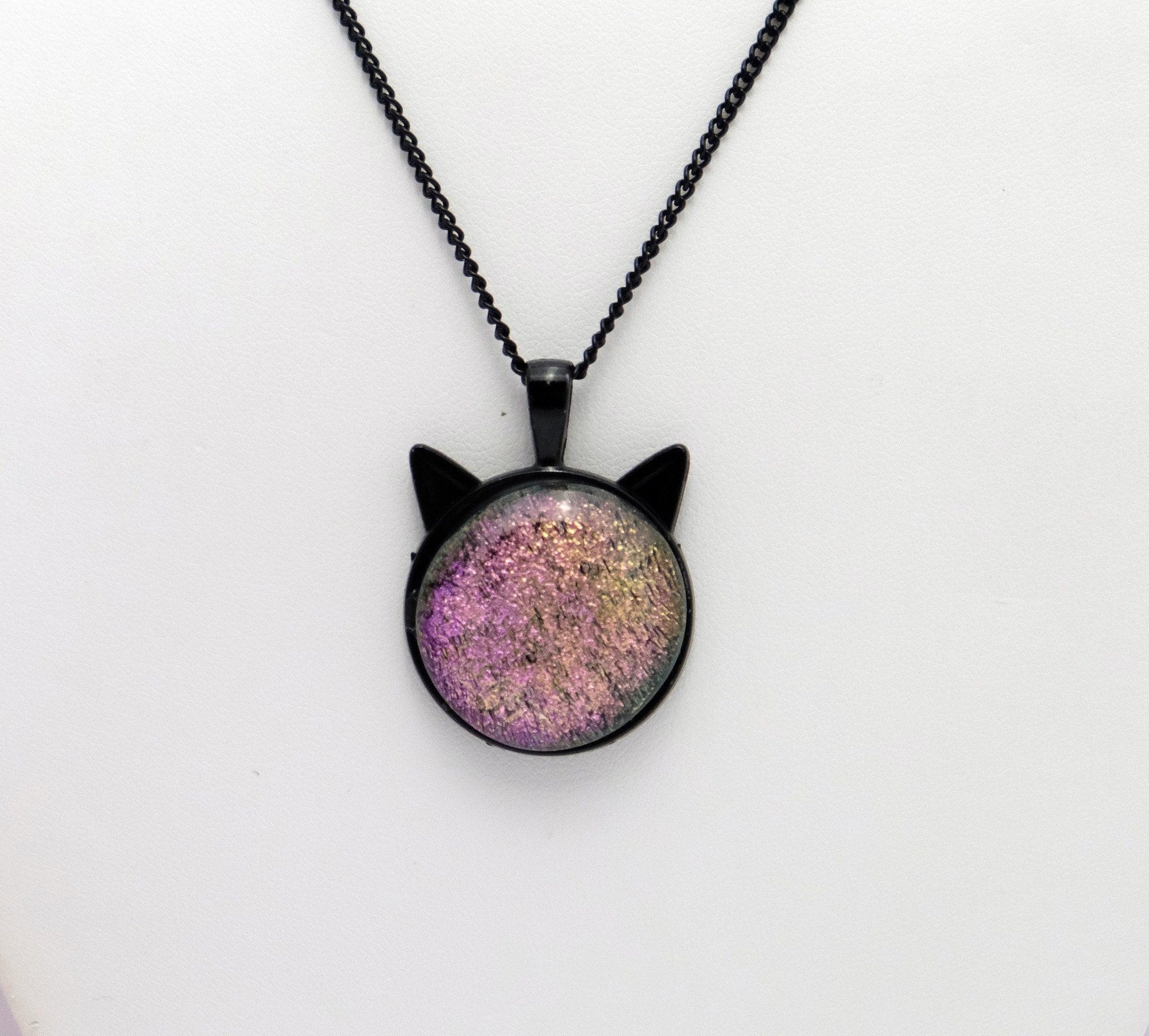 Black Cat pendant necklace, with color shifting pink/purple/green dichroic fused glass center stone on a 20 inch black chain seeds glassworks seedsglassworks