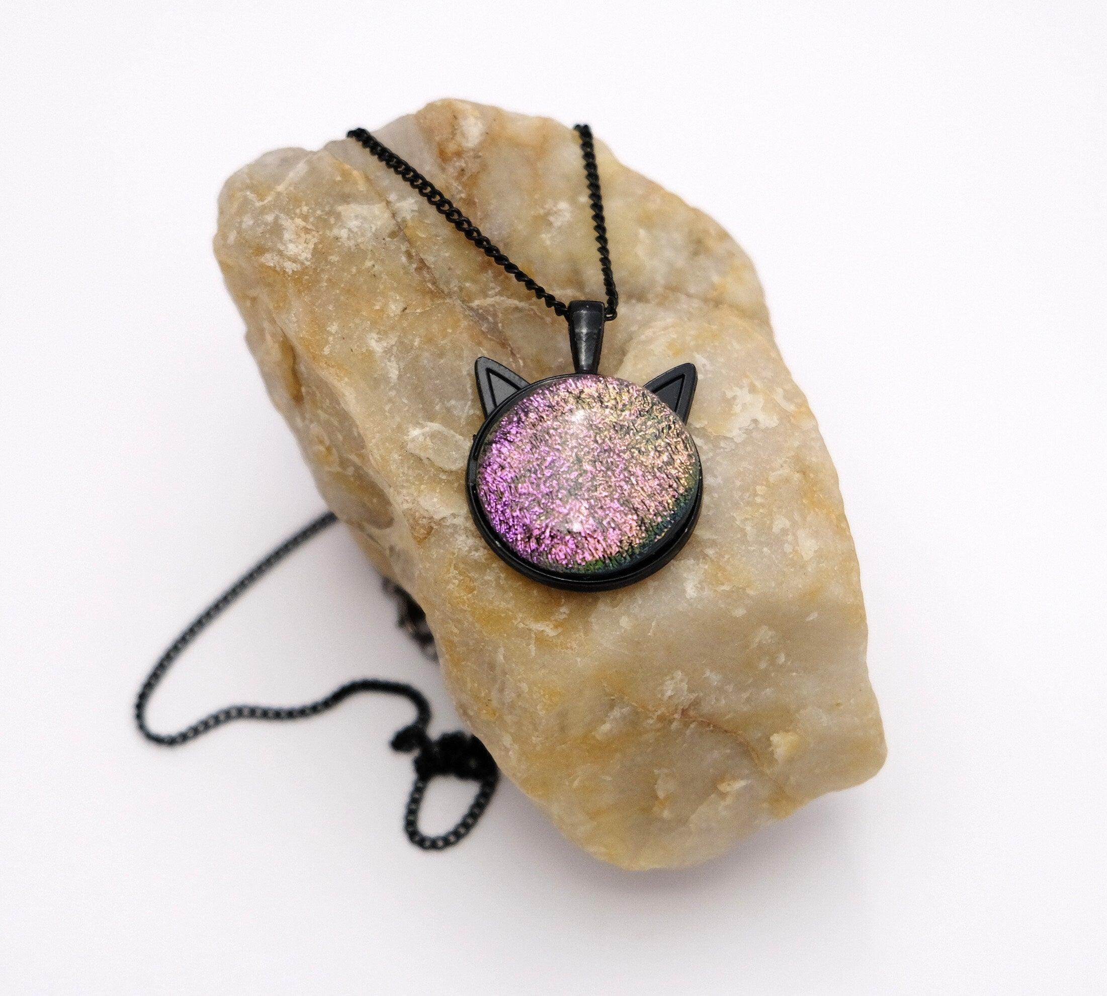 Products Black Cat pendant necklace, with color shifting pink/purple/green dichroic fused glass center stone on a 20 inch black chain seeds glassworks seedsglassworks