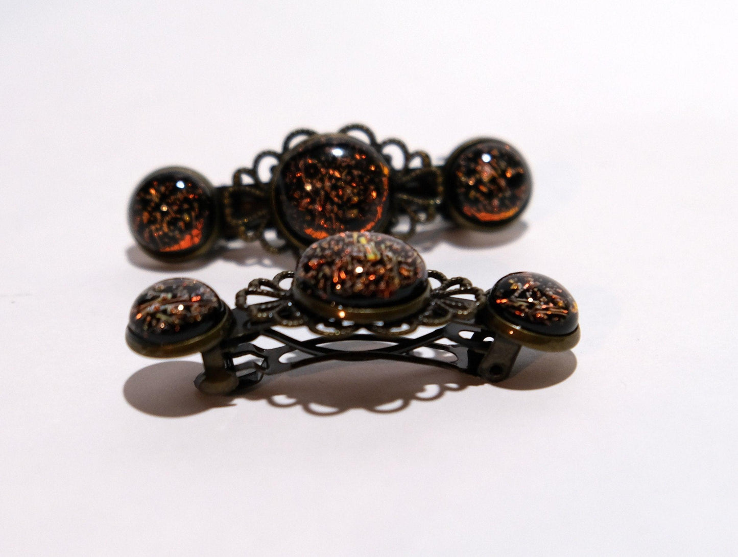 Barrette pair, bronze flowers with dark orange dichroic fused glass cabochons, french clip, 2 1/4 inches