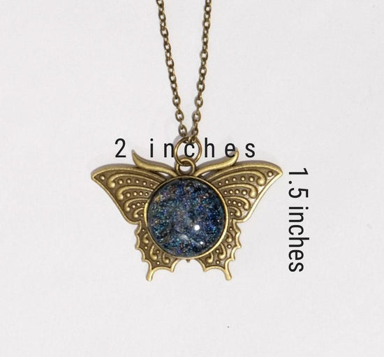 Butterfly pendant necklace, brass tone with blue/multicolor dichroic fused glass center stone on a 20 inch brass toned chain seeds glassworks seedsglassworks