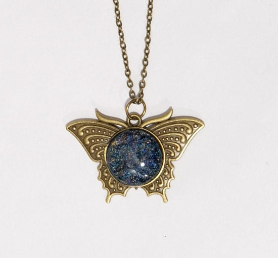 Butterfly pendant necklace, brass tone with blue/multicolor dichroic fused glass center stone on a 20 inch brass toned chain seeds glassworks seedsglassworks
