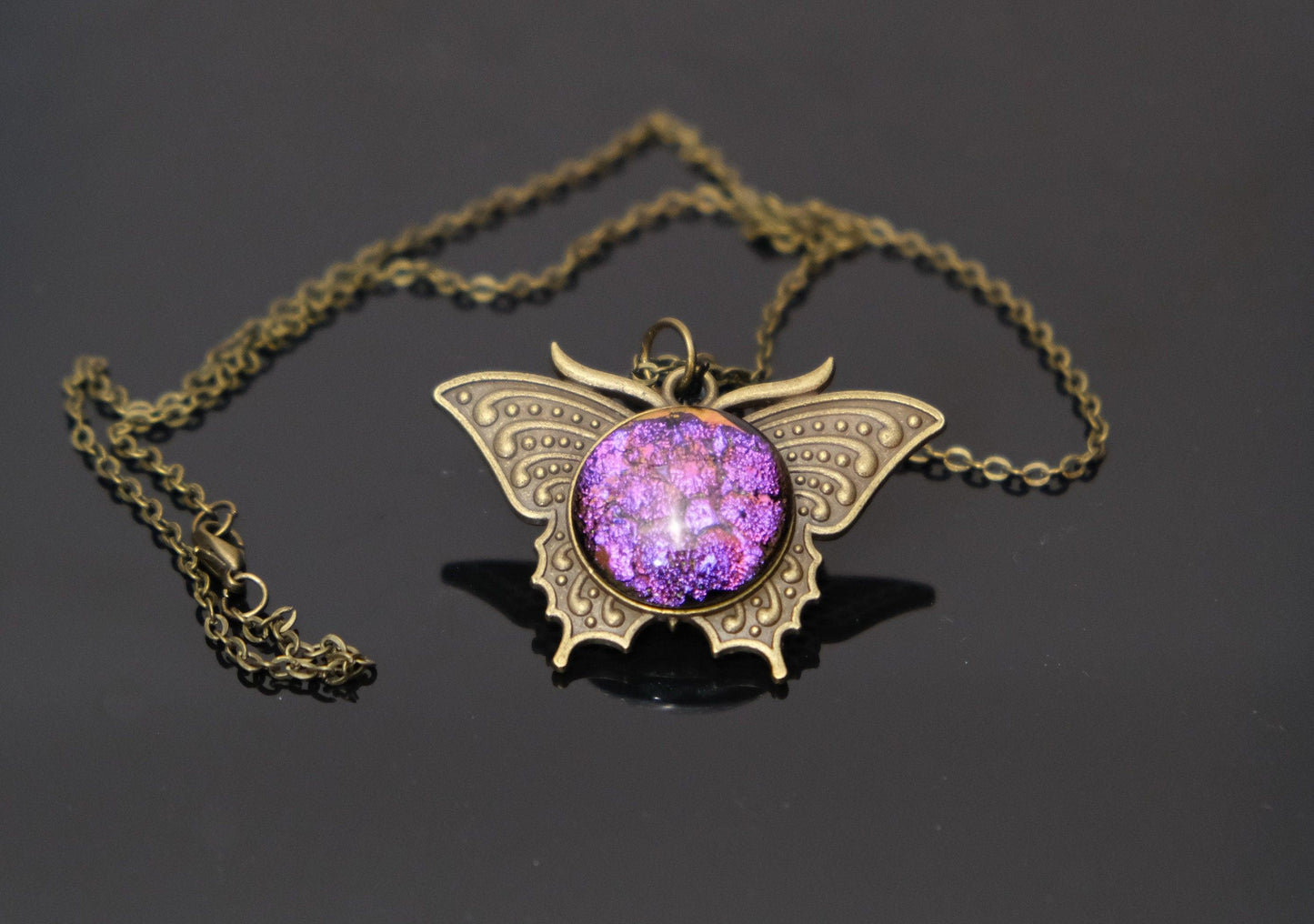 Butterfly pendant necklace, brass tone with dark purple dichroic fused glass center stone on a 20 inch brass tone chain seeds glassworks seedsglassworks