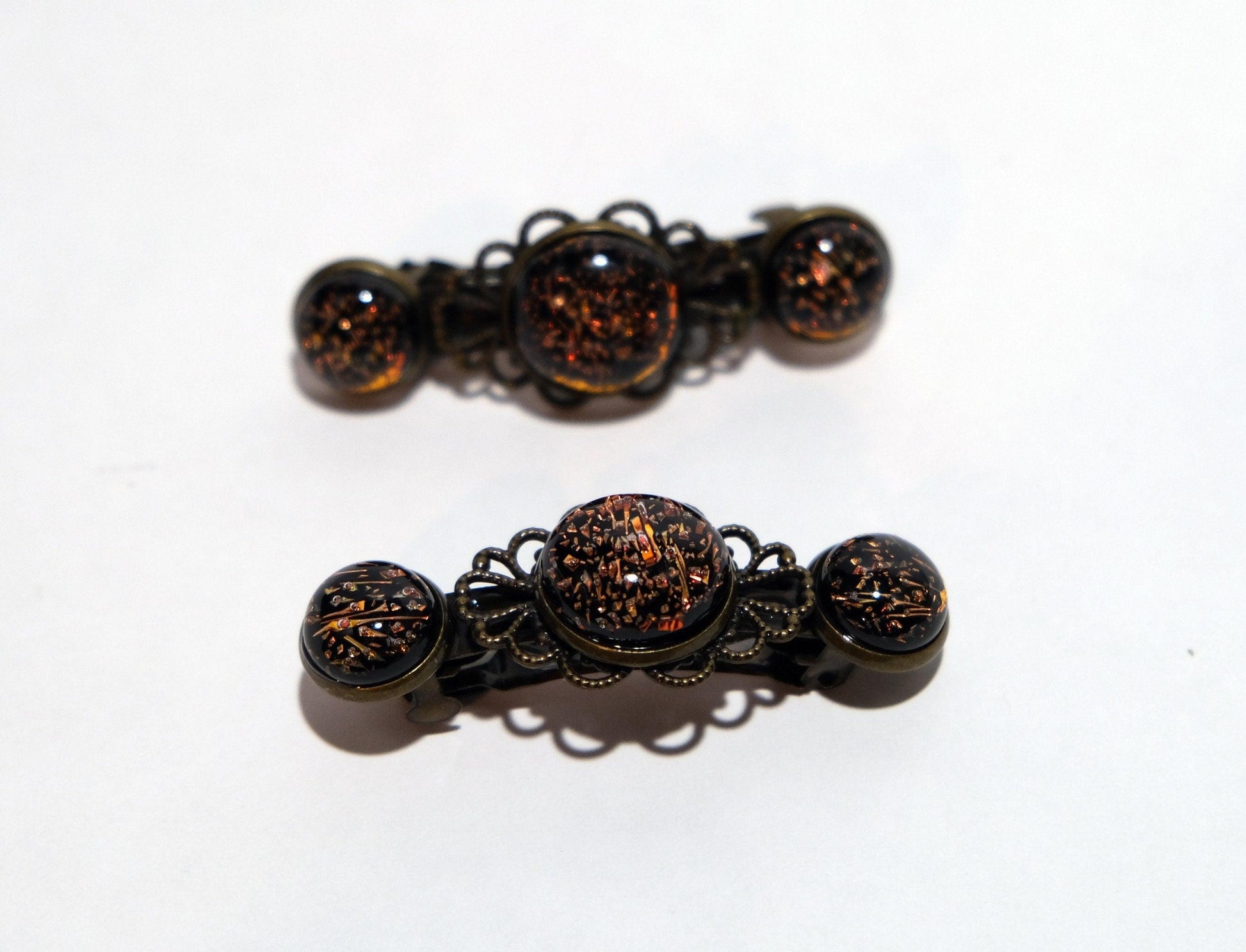 Barrette pair, bronze flowers with dark orange dichroic fused glass cabochons, french clip, 2 1/4 inches seeds glassworks seedsglassworks