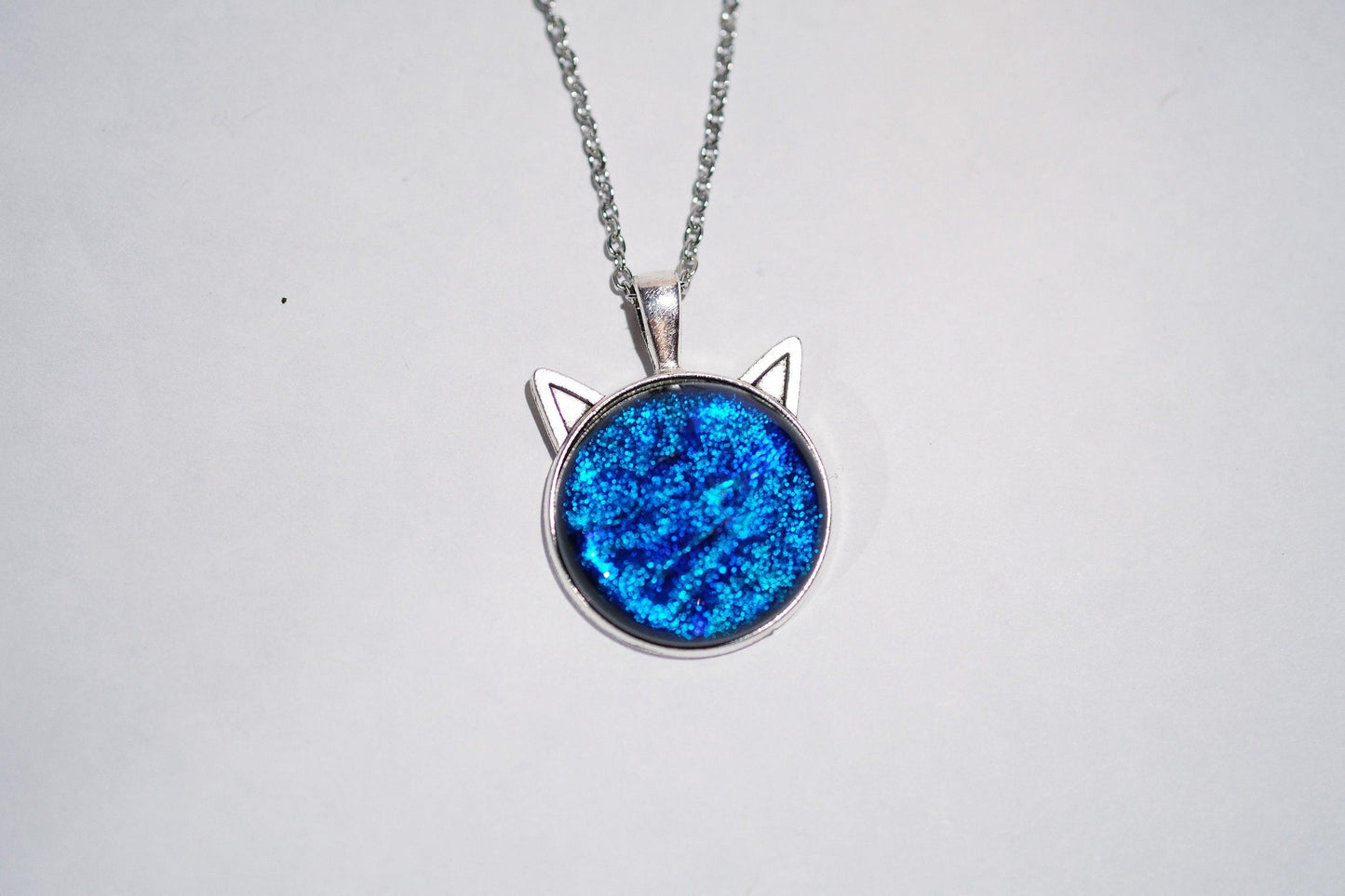 Silver Cat pendant necklace, with blue sparkling dichroic fused glass center stone on a 20 inch steel chain seeds glassworks seedsglassworks